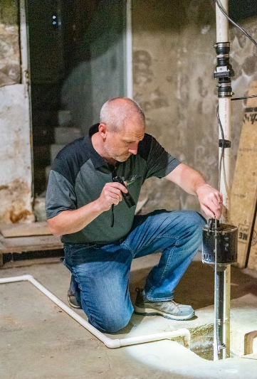 Inspecting a sump pump during home inspection